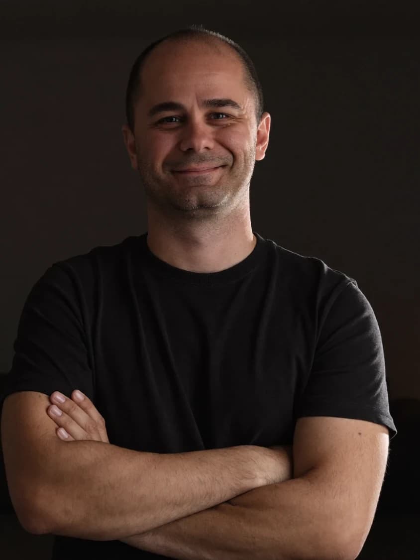 Đorđe Grujović, arms folded, lit from one side in a dark room
